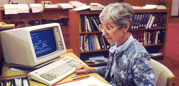 woman works on computer in office 1980s