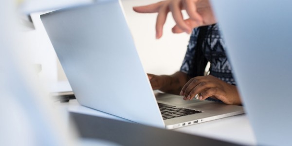 hands pointing at computer screen